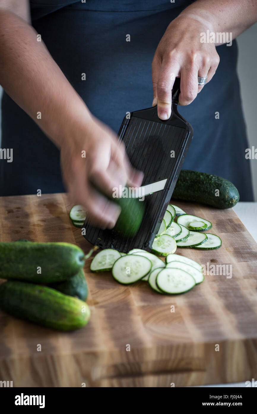 Cucumbers being sliced to be pickled Stock Photo