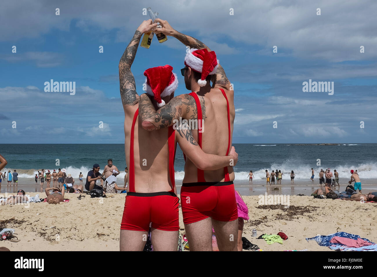 men toasting a merry christmas on Coogee beach, Sydney, New South Wales, Australia Stock Photo