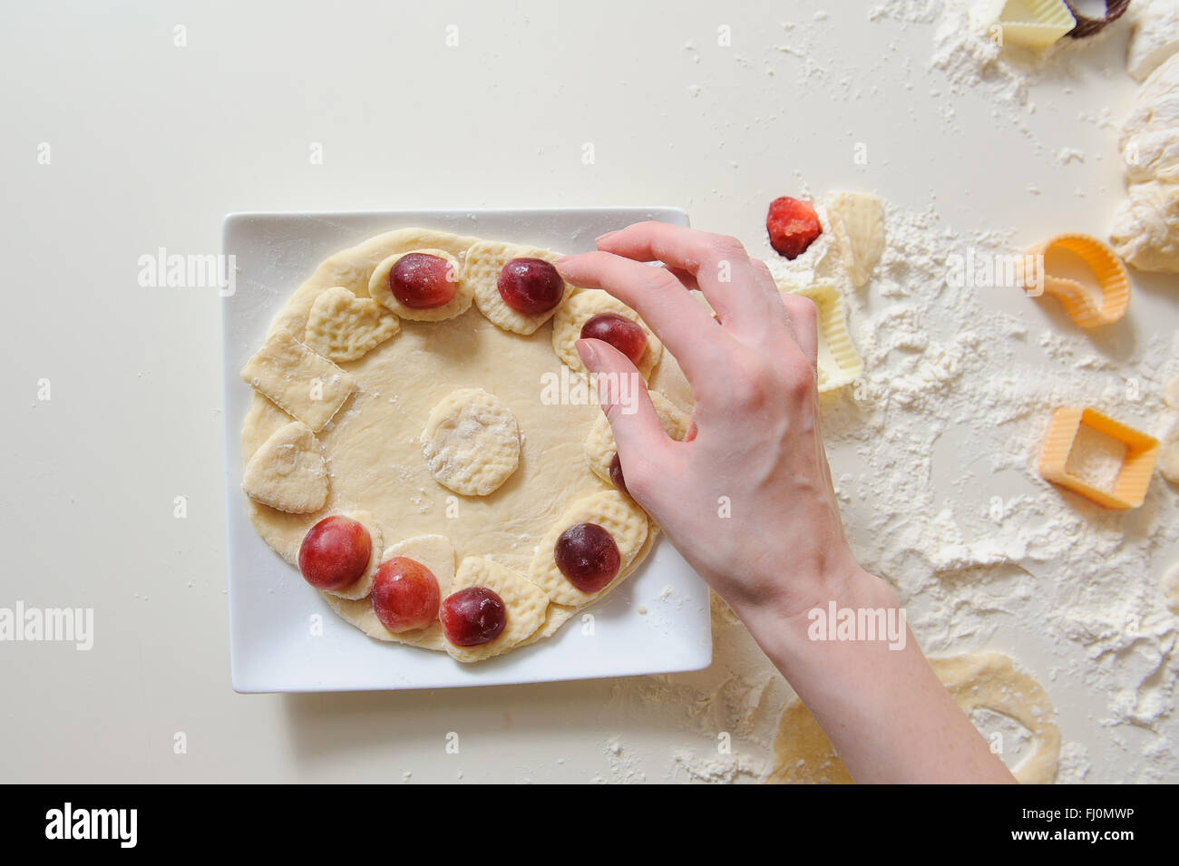 close up of female hands making cookies from fresh dough at home. dough ...