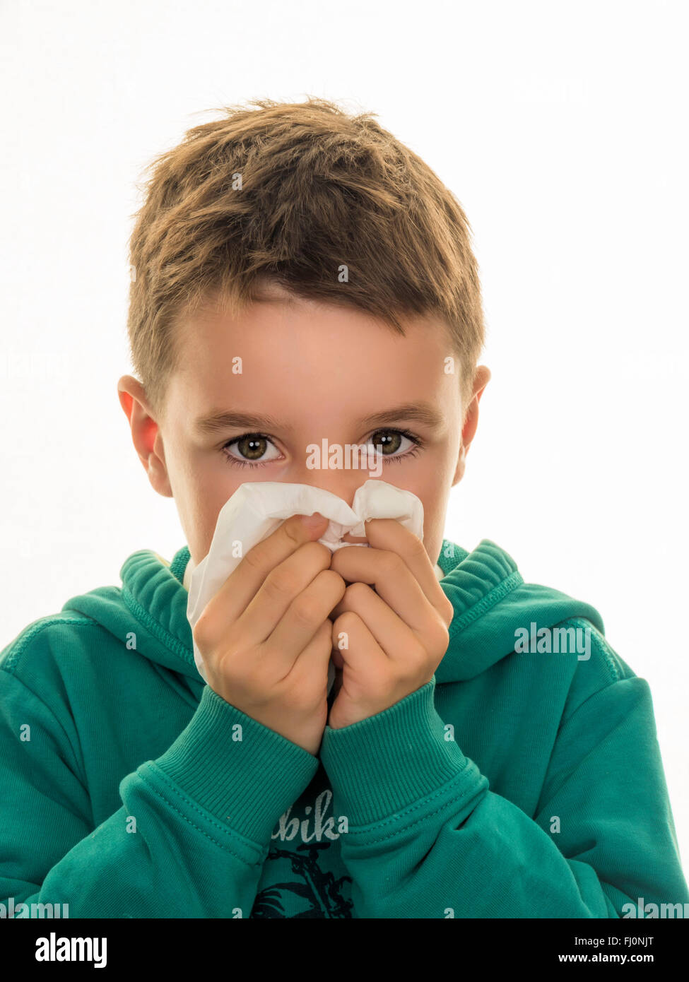 Portrait of boy blowing his nose Stock Photo
