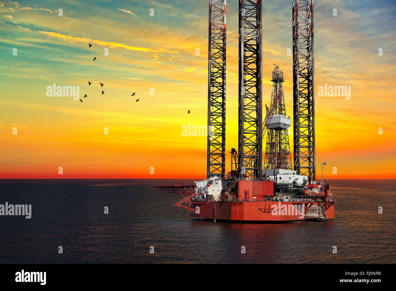 Oil drilling rig in sunset time. Stock Photo