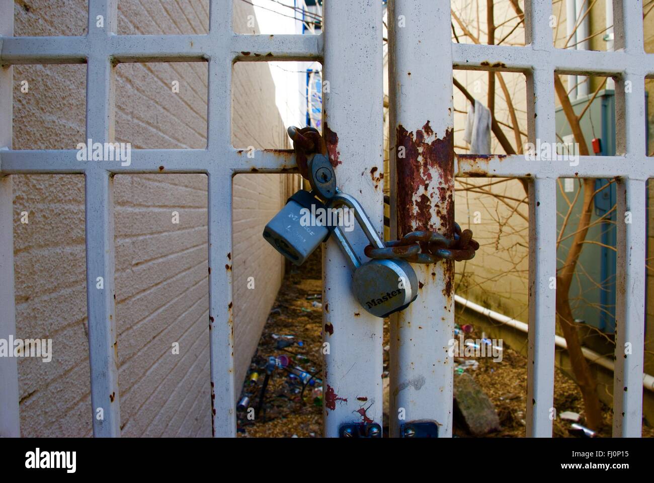 Two locks on rusty chain on fence in uptown charlotte Stock Photo