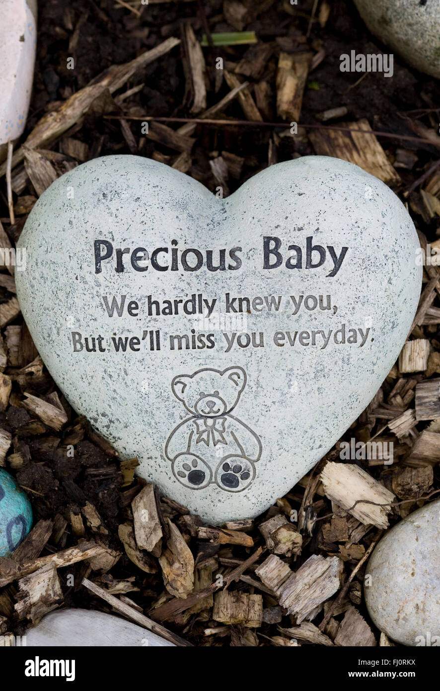 Hand Painted Remembrance Stones in a Graveyard 'Heart shaped Precious baby Stone' Stock Photo