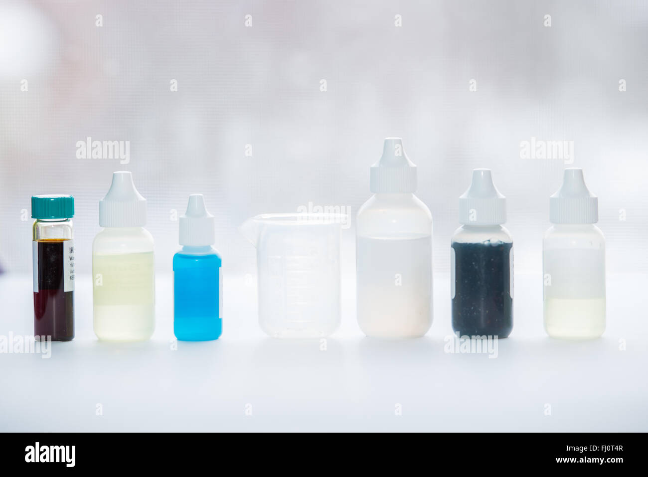 Row of science experiment apparatus including vials, bottles and a
