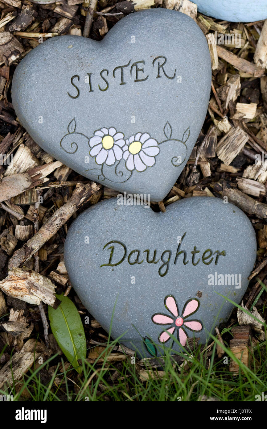 Hand Painted Remembrance Stones in a Graveyard, Heart shaped Sister and daughter Stone Stock Photo