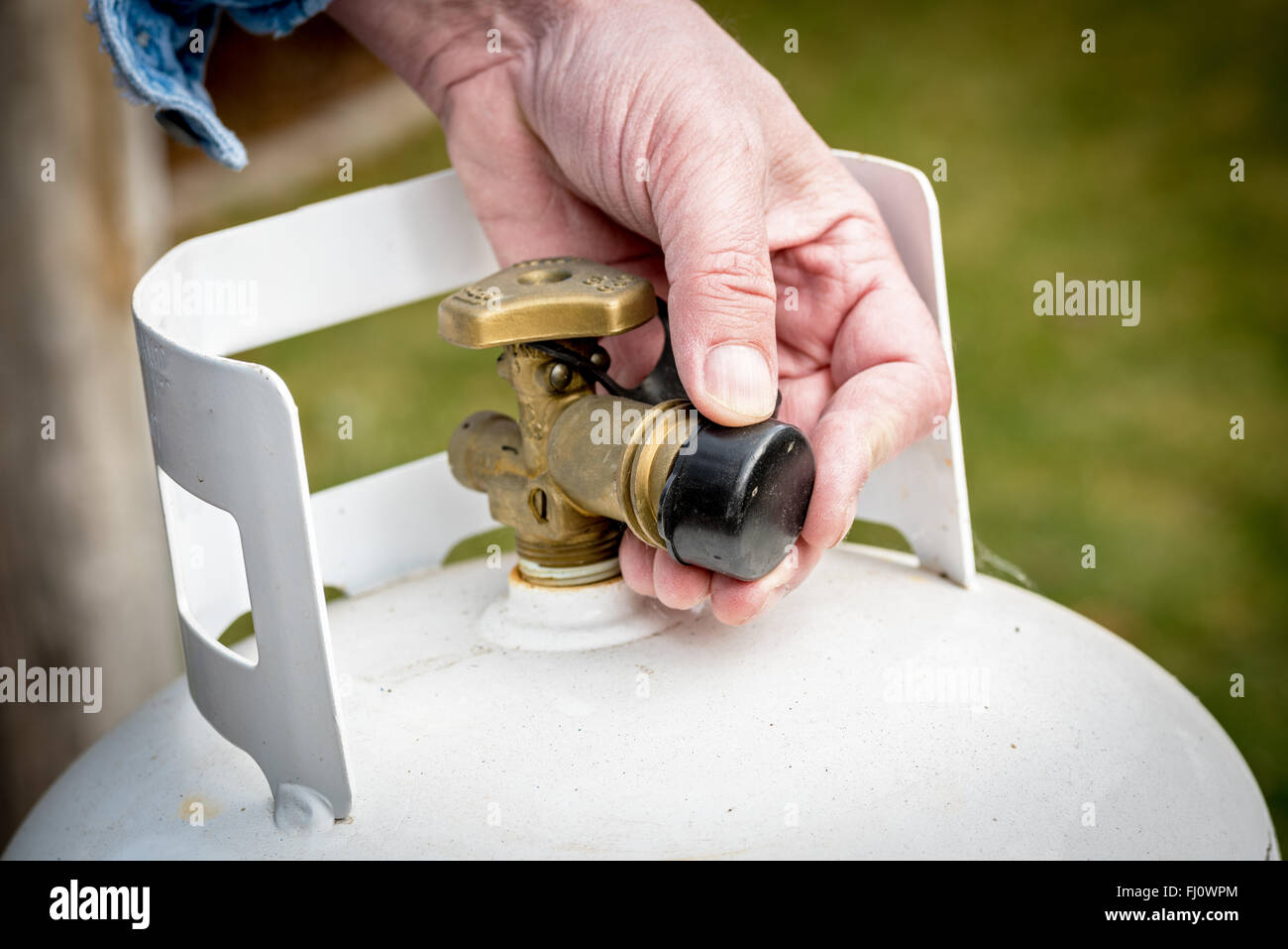 Man puts a plastic cap on propane tank Stock Photo Alamy