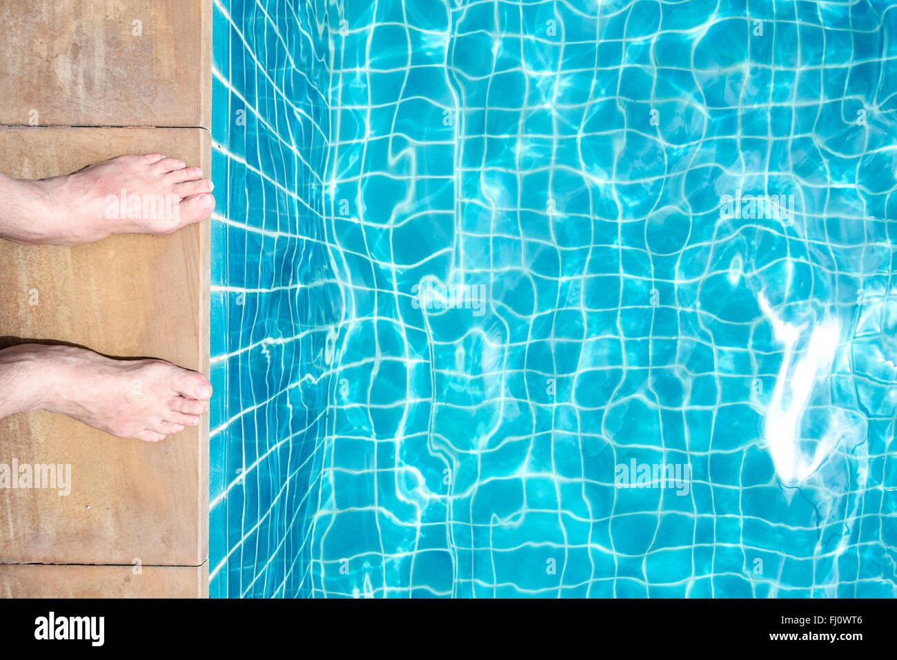 Feet of a man at pool edge Stock Photo - Alamy