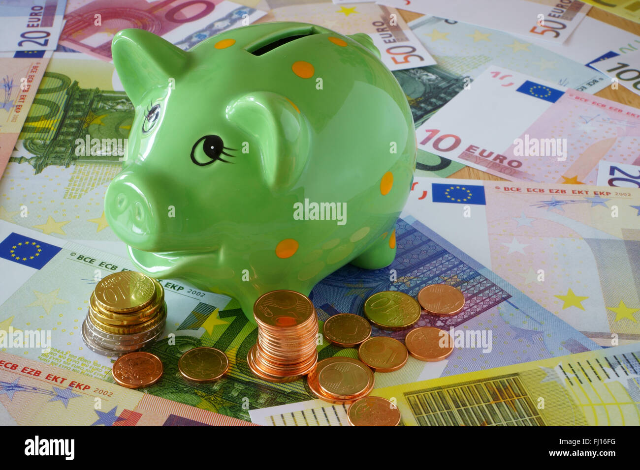 Green Piggy Bank on a background made of Euro banknotes und coins Stock ...