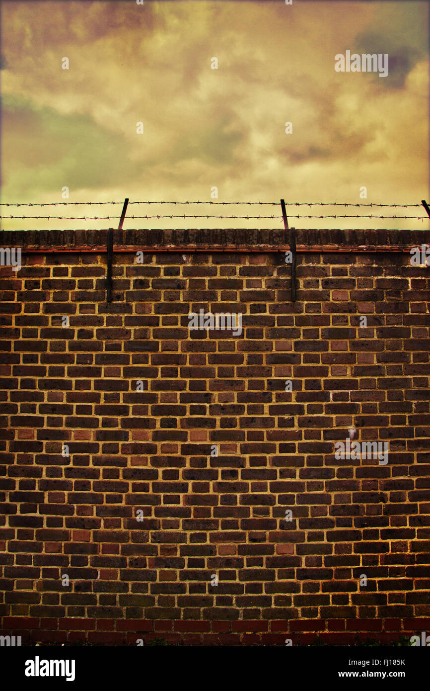 View of barbed wire topped wall Stock Photo - Alamy
