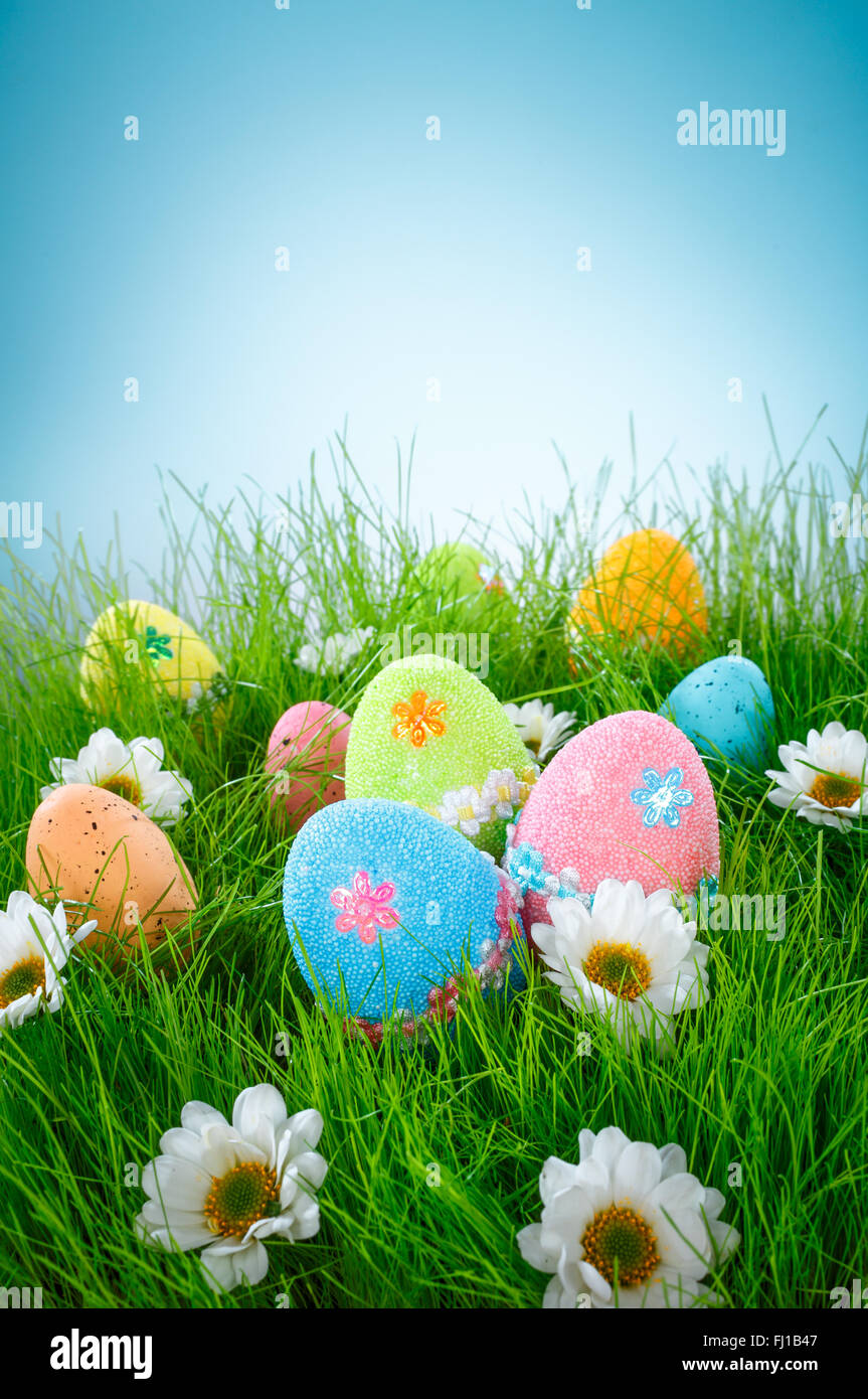Decorated easter eggs in the grass on blue sky background Stock Photo ...