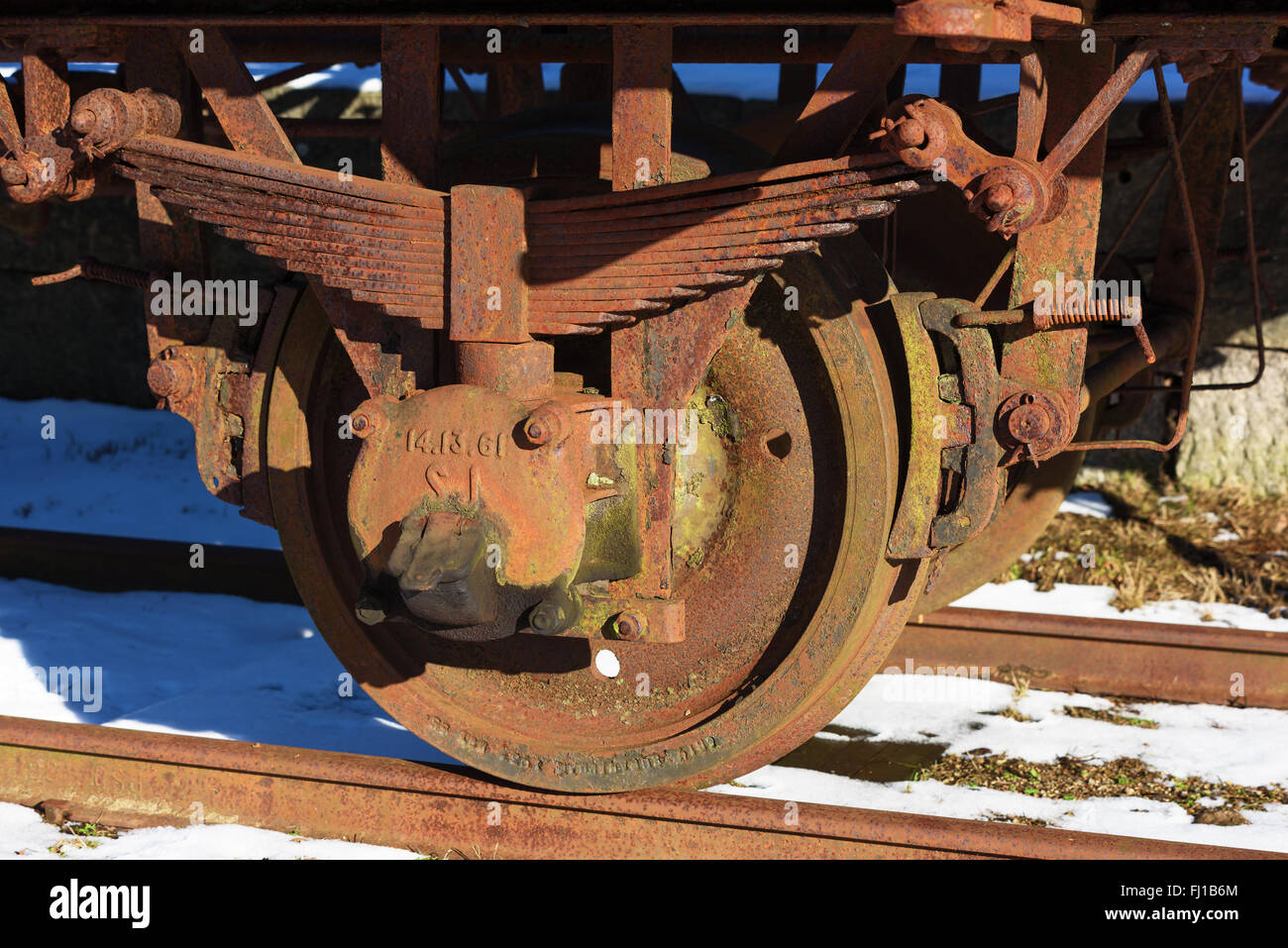 Hovmansbygd, Sweden - February 16, 2016: Rusty old iron wheel from an old railway wagon. Wagon no longer in use and rail is rust Stock Photo