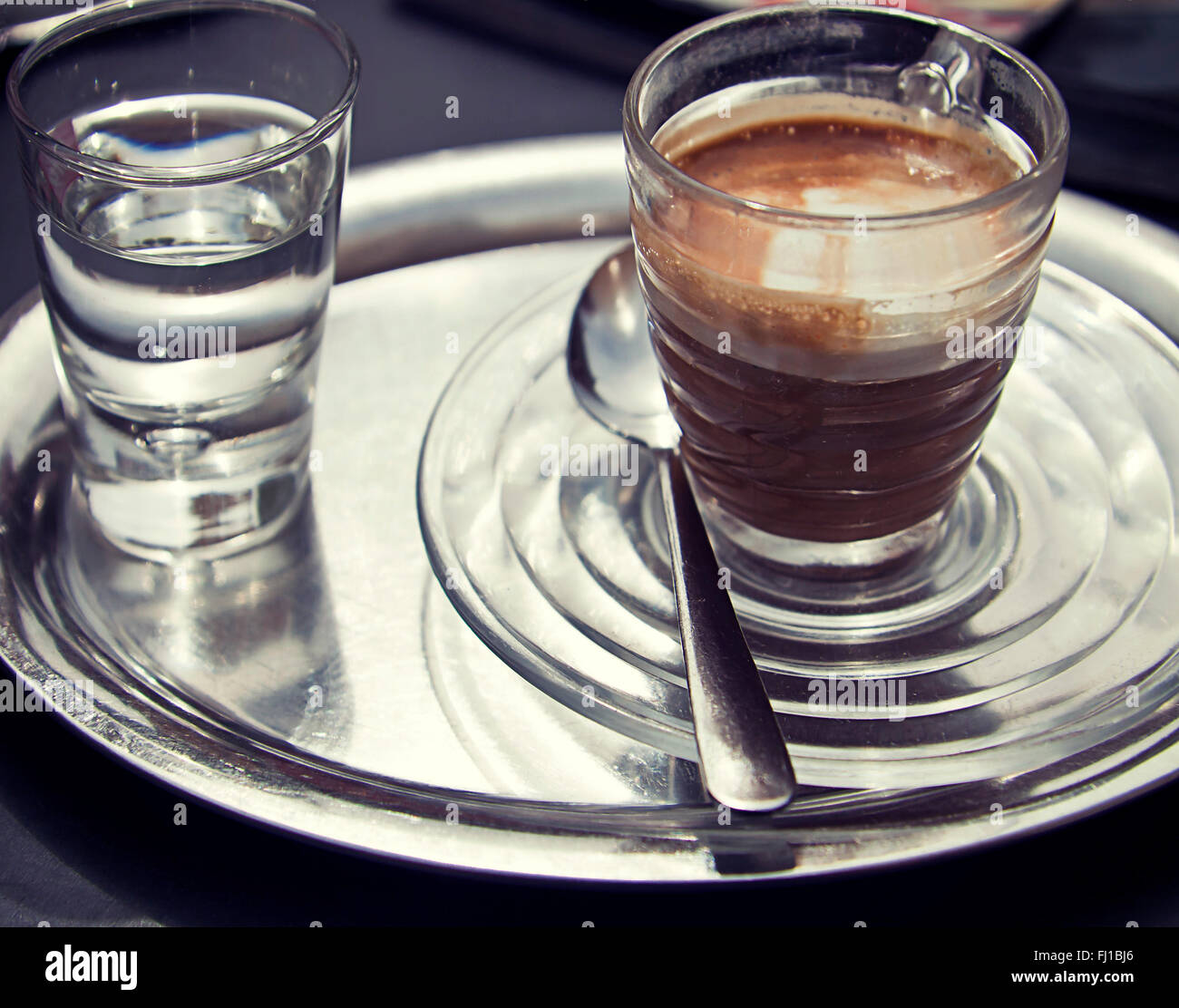 https://c8.alamy.com/comp/FJ1BJ6/espresso-macchiato-on-metall-tray-and-glass-with-water-FJ1BJ6.jpg