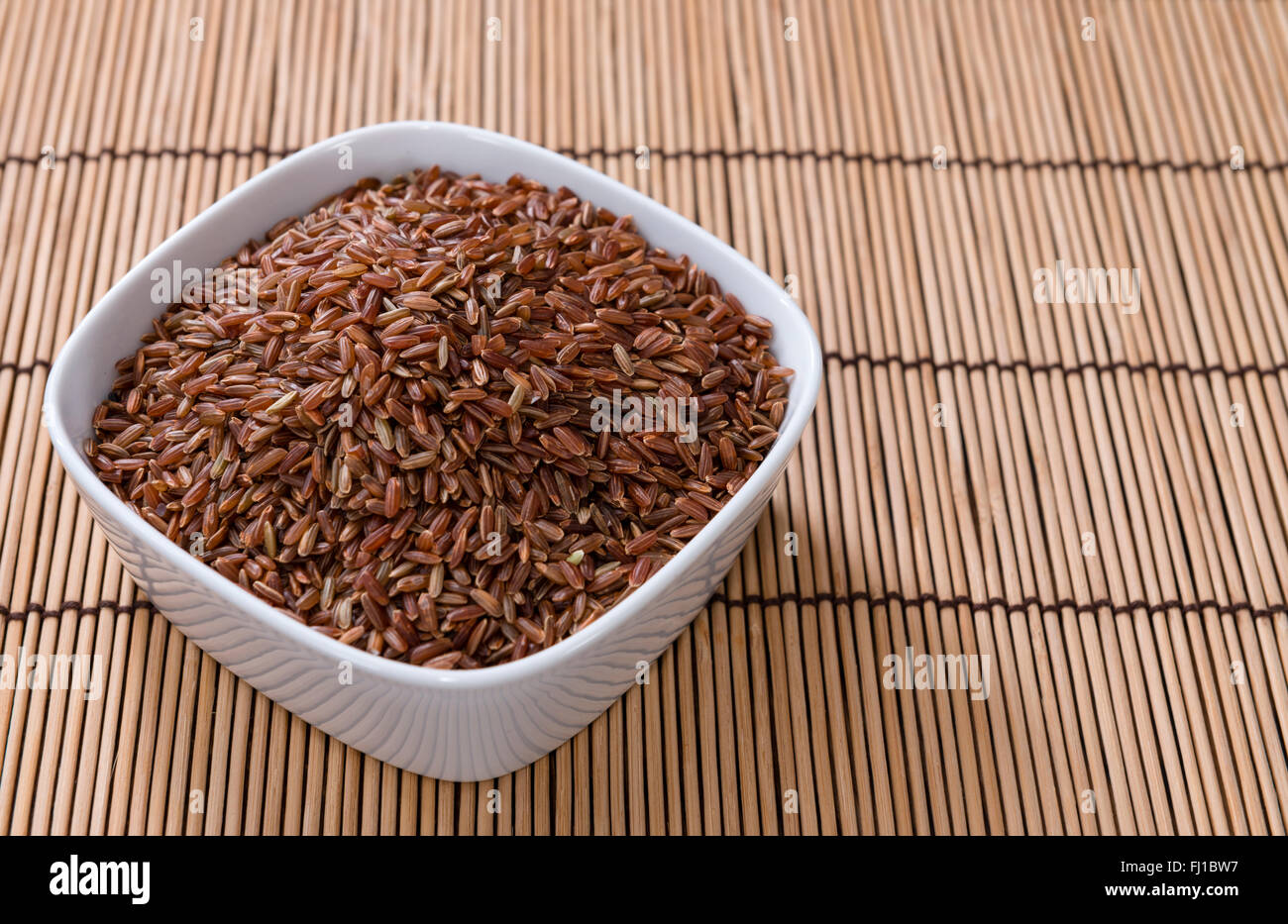 Portion of red Rice (close-up shot) on wooden background Stock Photo ...
