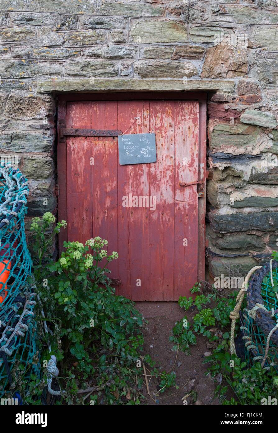 Old door surrounded by lobster pots, Hope Cove, Devon, England Stock