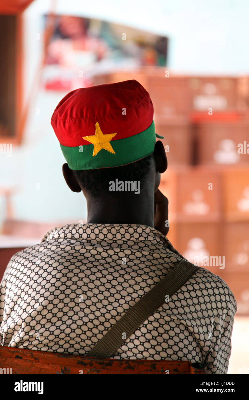 Portait of a man in Burkina Faso seen from the back with a hat with the colors and the star of the Burkina faso national flag Stock Photo