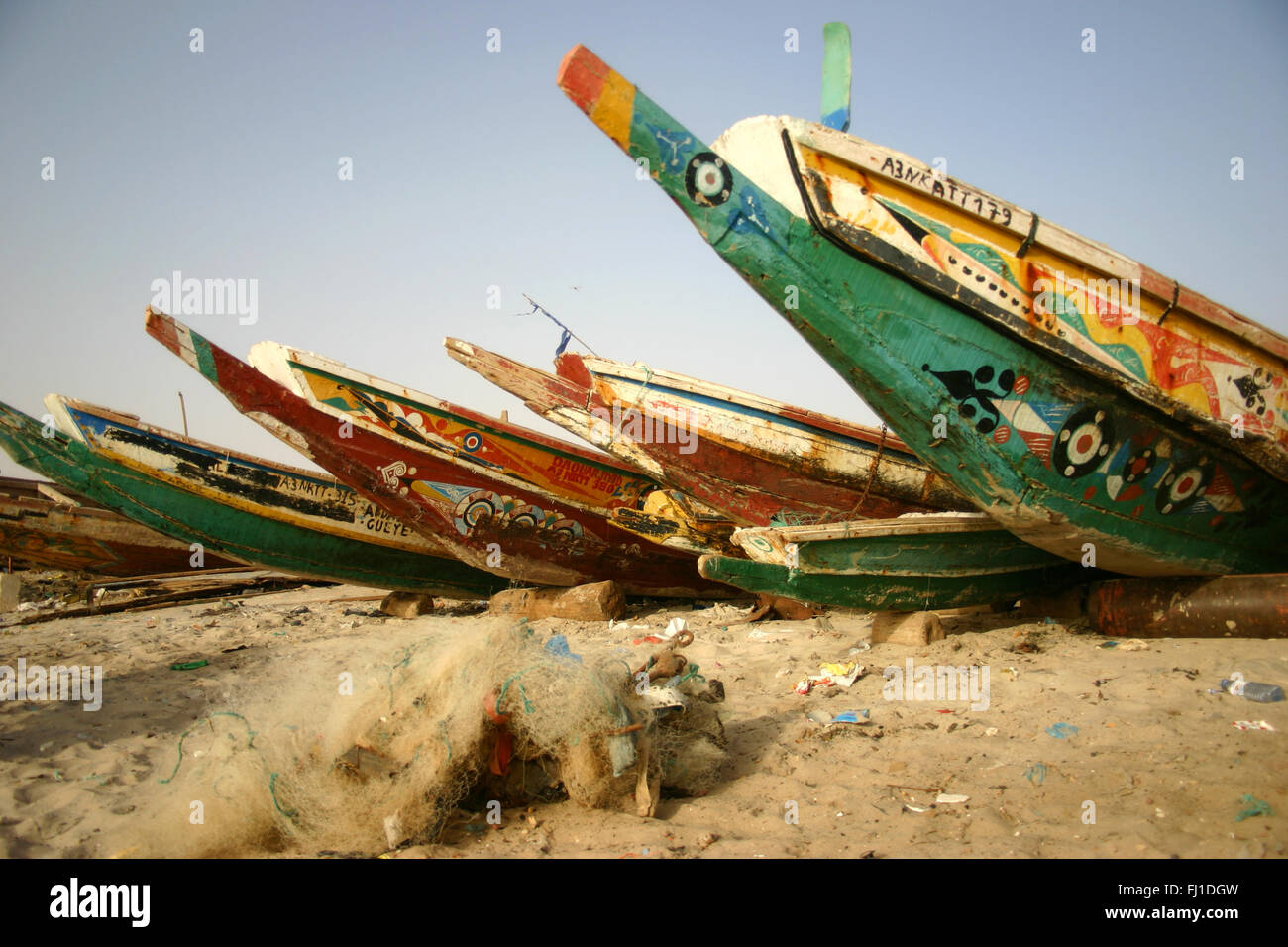 people and boats canoes on the beach and traditional harbor of Nouakchott , Mauritania Stock Photo