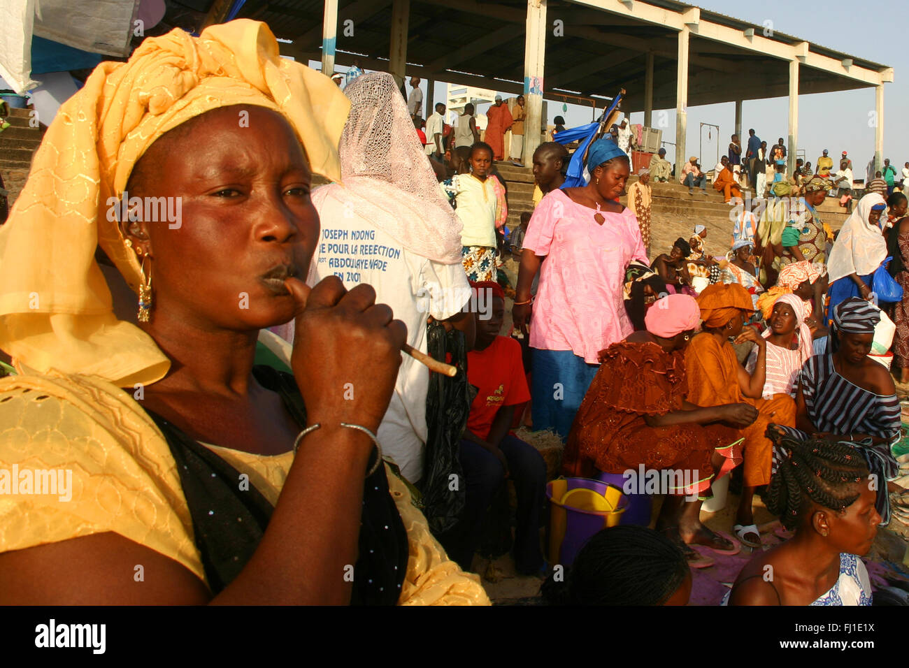 Portrait of a woman selling fish in the crowd in Mbour fish market at the end of the day , Senegal Stock Photo