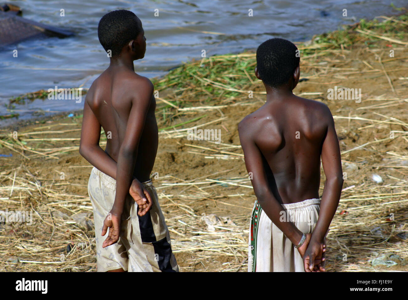 Two young black African guys boys seen from the back along Senegal river in Segou , Mali Stock Photo