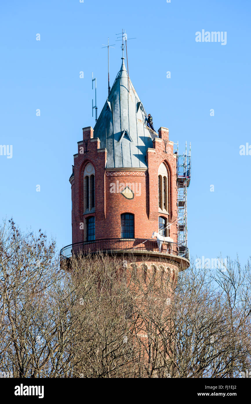 Ronneby, Sweden - February 26, 2016: High altitude repairs on the roof of the old water tower in town. One person is up on the v Stock Photo