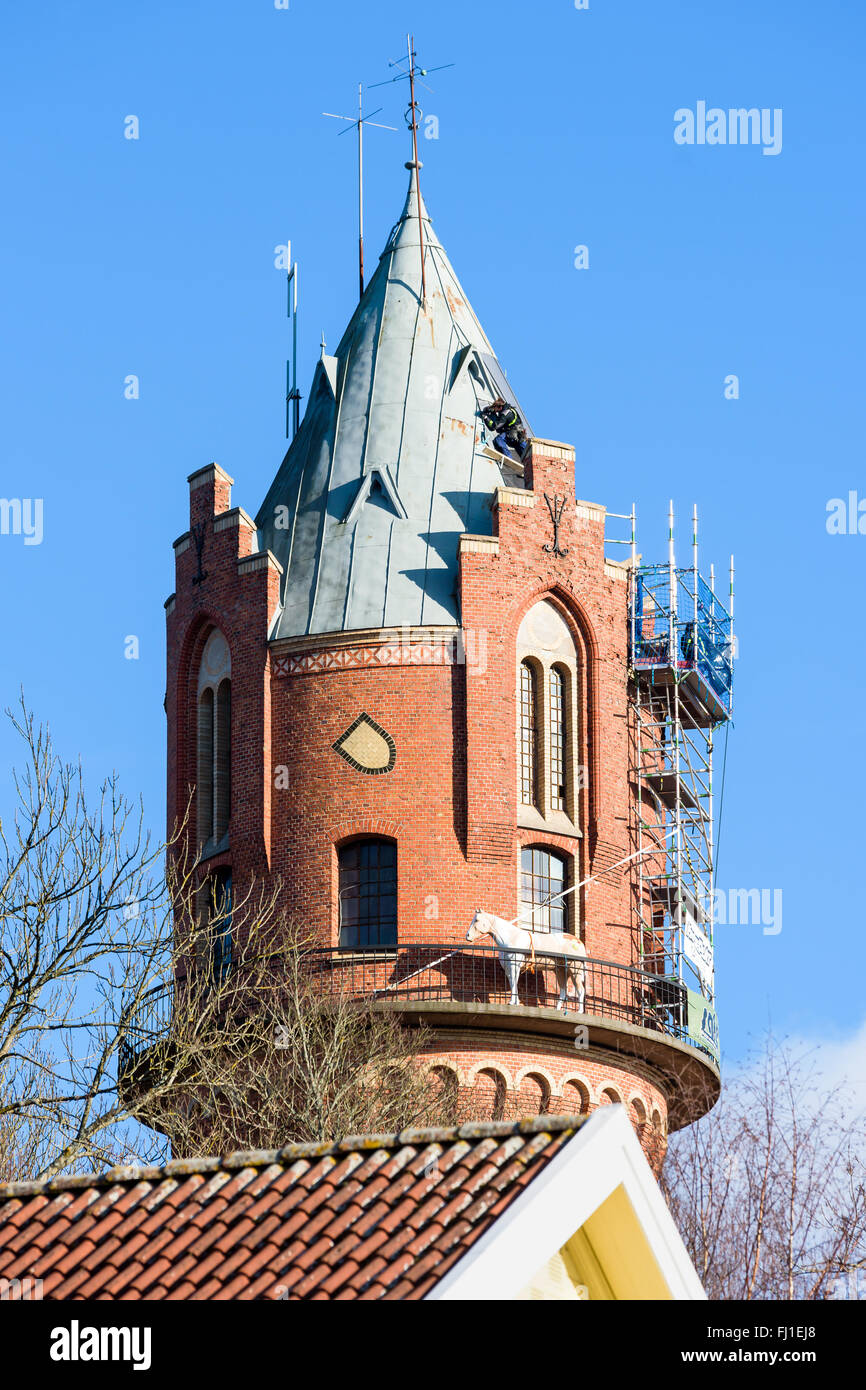 Ronneby, Sweden - February 26, 2016: High altitude repairs on the roof of the old water tower in town. One person is up on the v Stock Photo