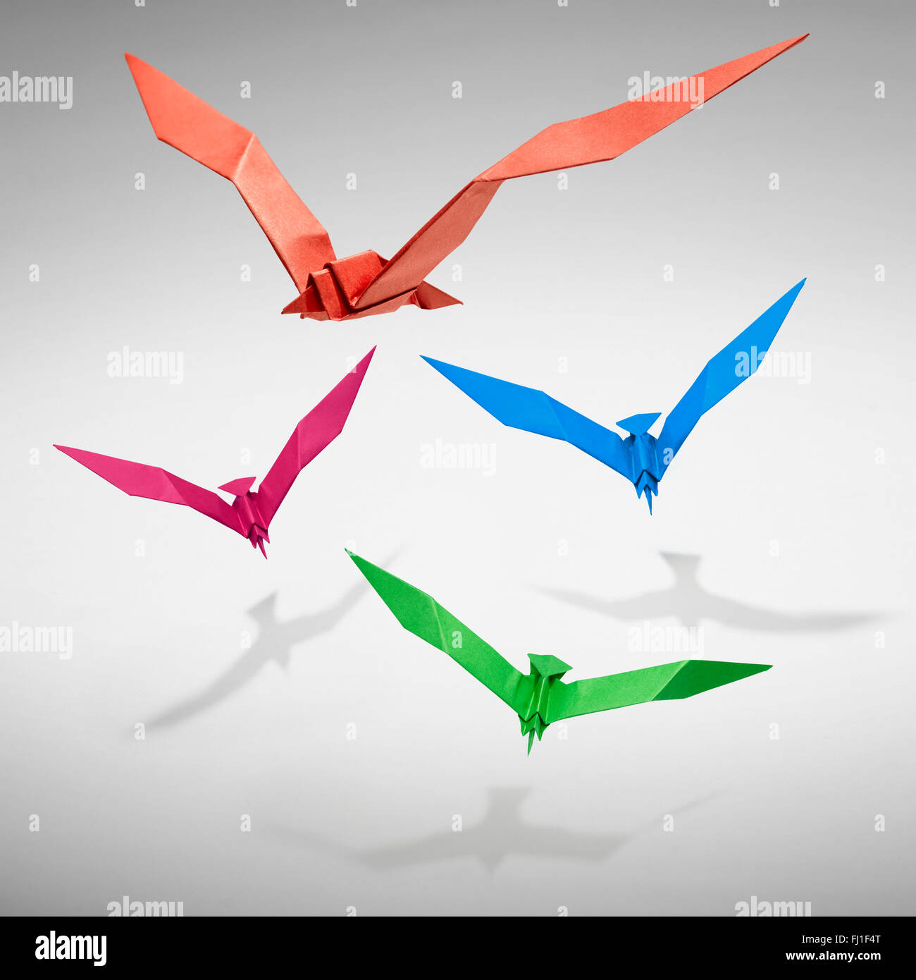 Group of flying birds in Origami, there is a path for each bird. Stock Photo