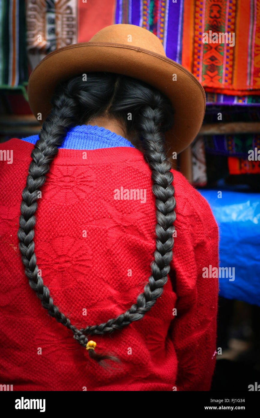 Peruvian woman with bowler hat and braids in Pisac market Stock Photo