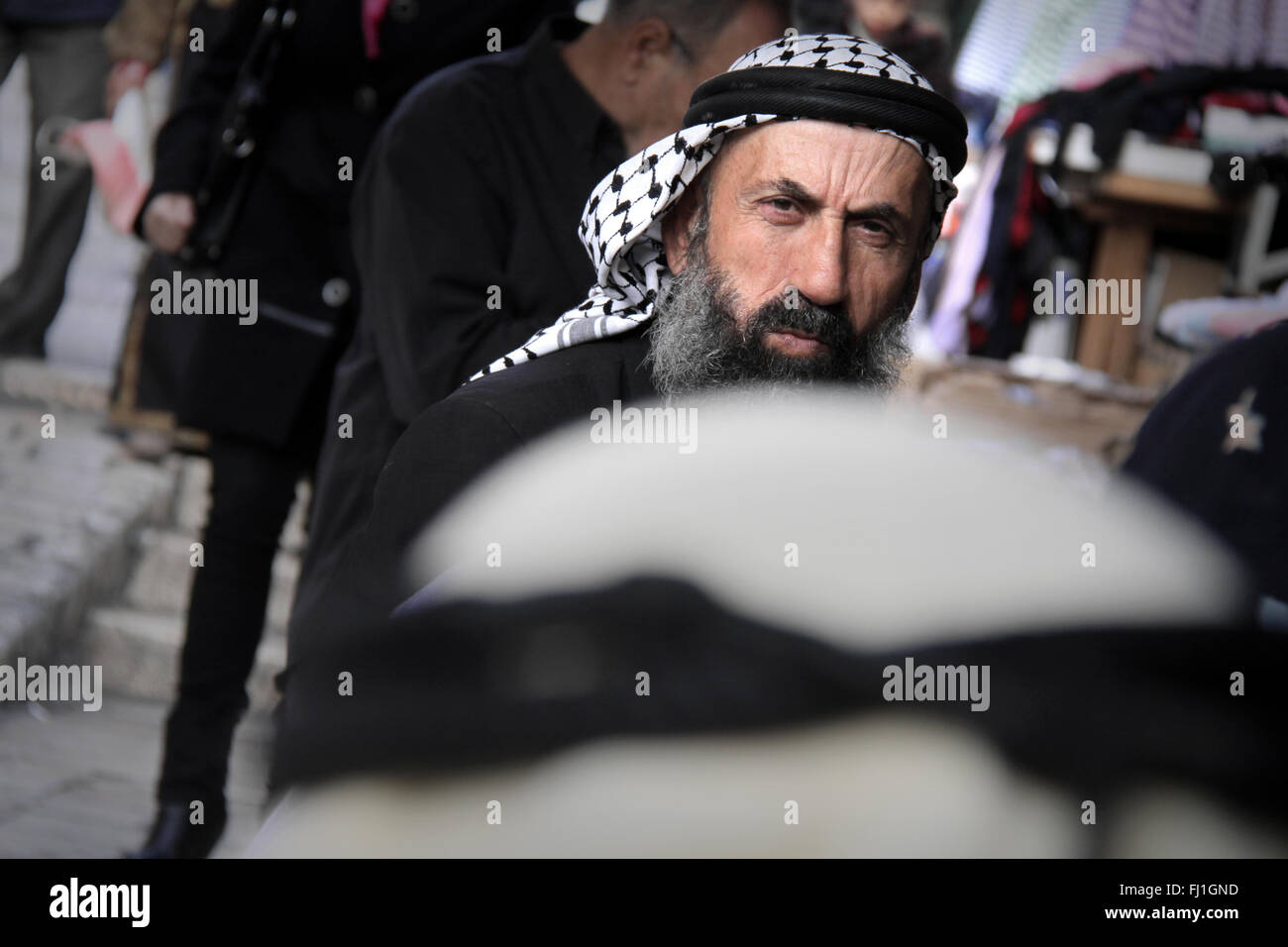 Arab  Palestinian man wearing keffieh in the crowd near Damascus gate in Jerusalem , Israel Stock Photo
