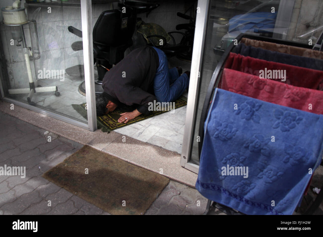 Man doing Friday prayer in his hairdresser shop in Amman, Jordan Stock Photo