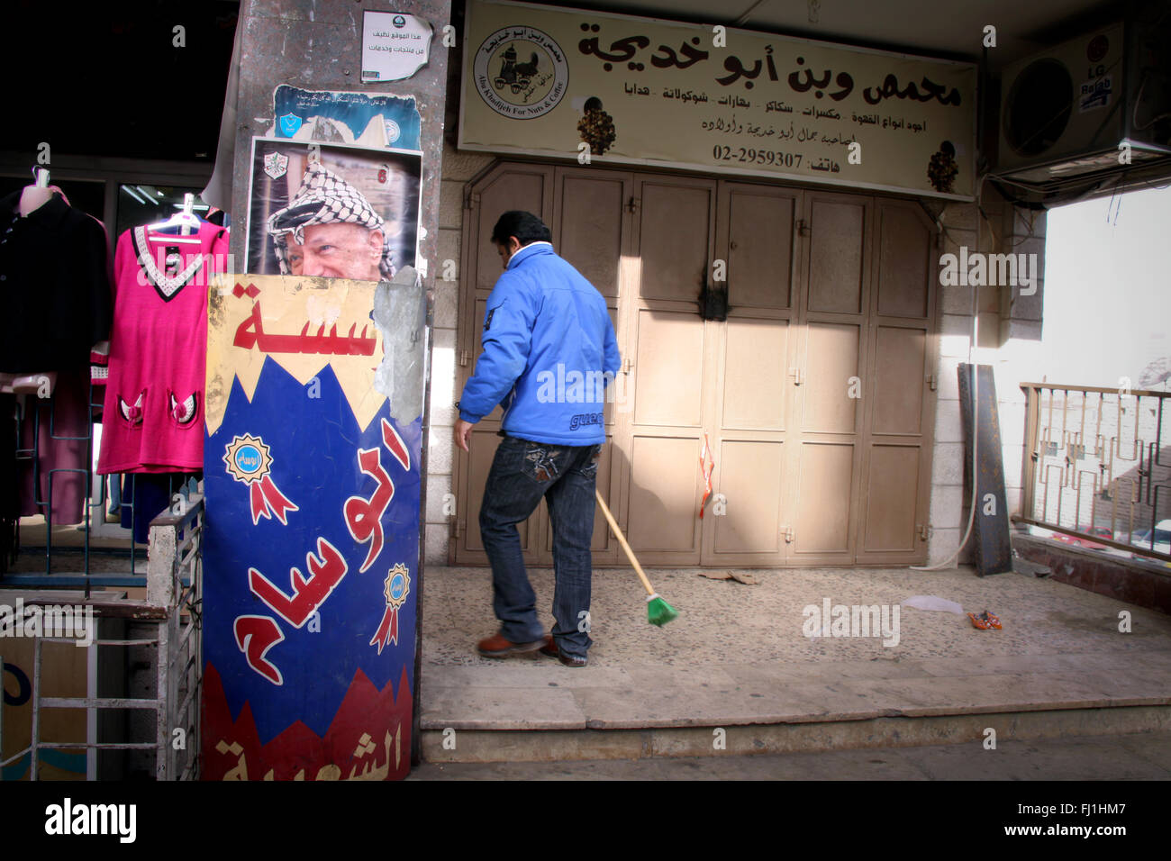 A man walks in the streets of Ramallah , Palestine , with portrait of Yasser Araphat on the wall Stock Photo