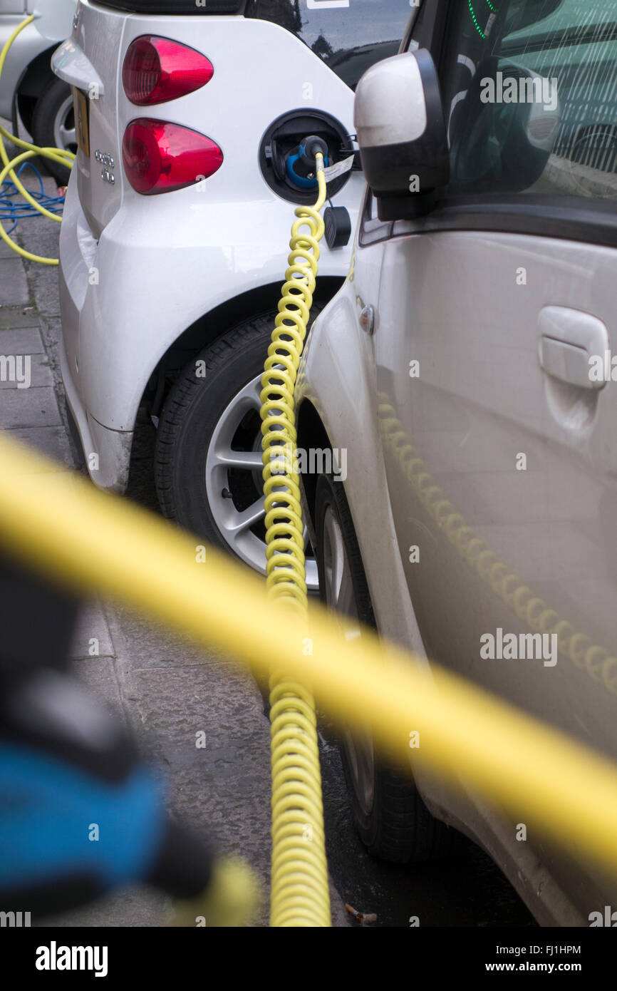 Electric vehicles plugged into charging points on a road in London, UK