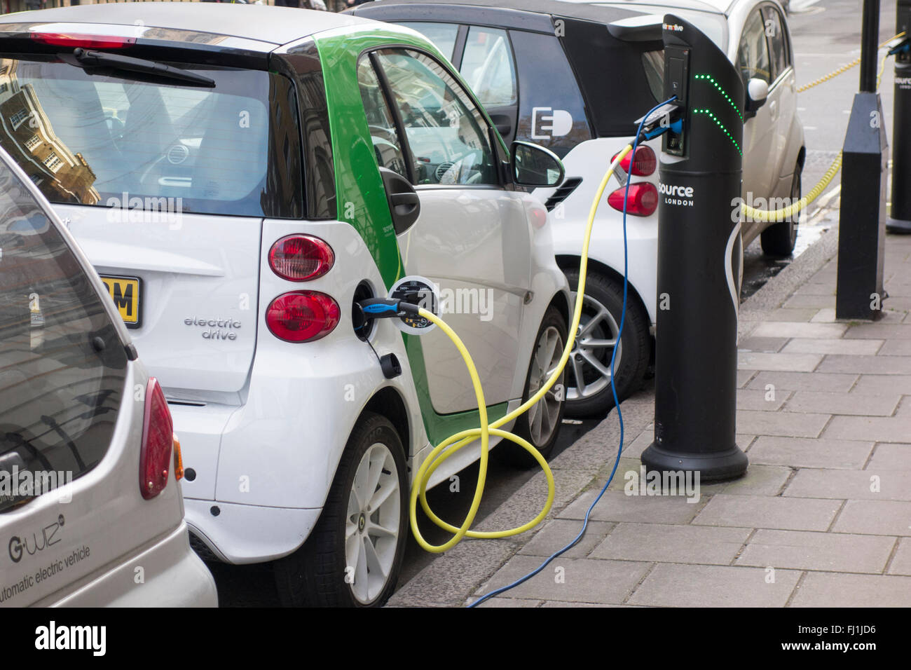 Electric vehicles plugged into charging points on a road in London, UK