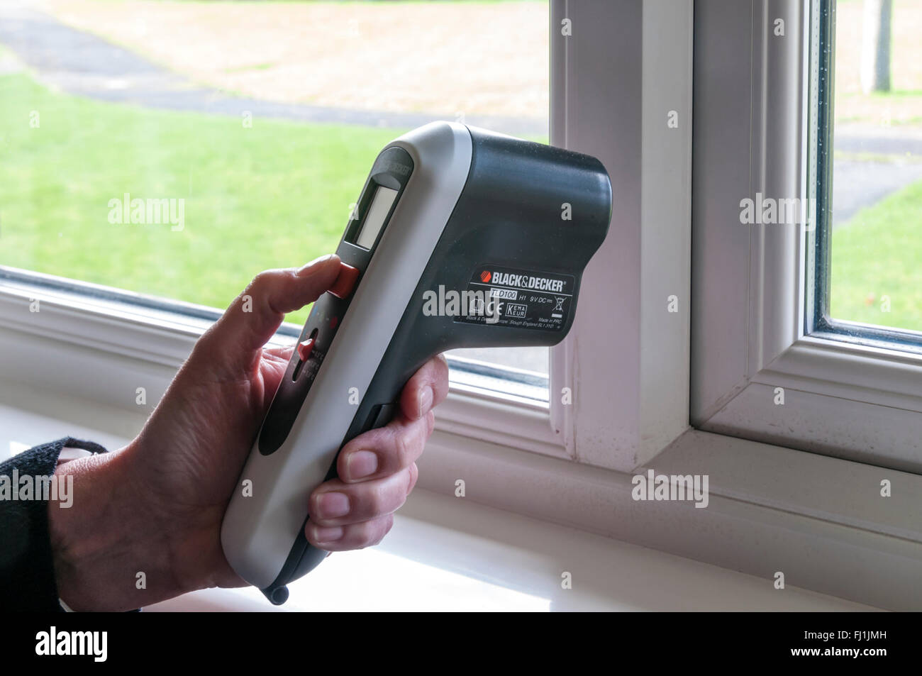 A Chartered Surveyor using a Thermal Leak Detector to help assess the efficiency of a property's insulation. Stock Photo