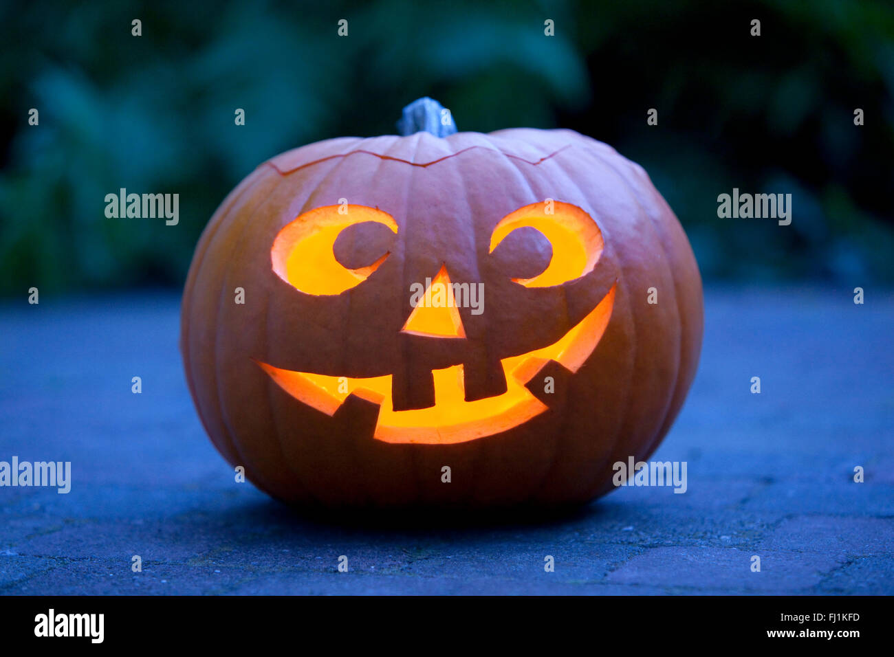 Illuminated Halloween pumpkin in the garden Stock Photo
