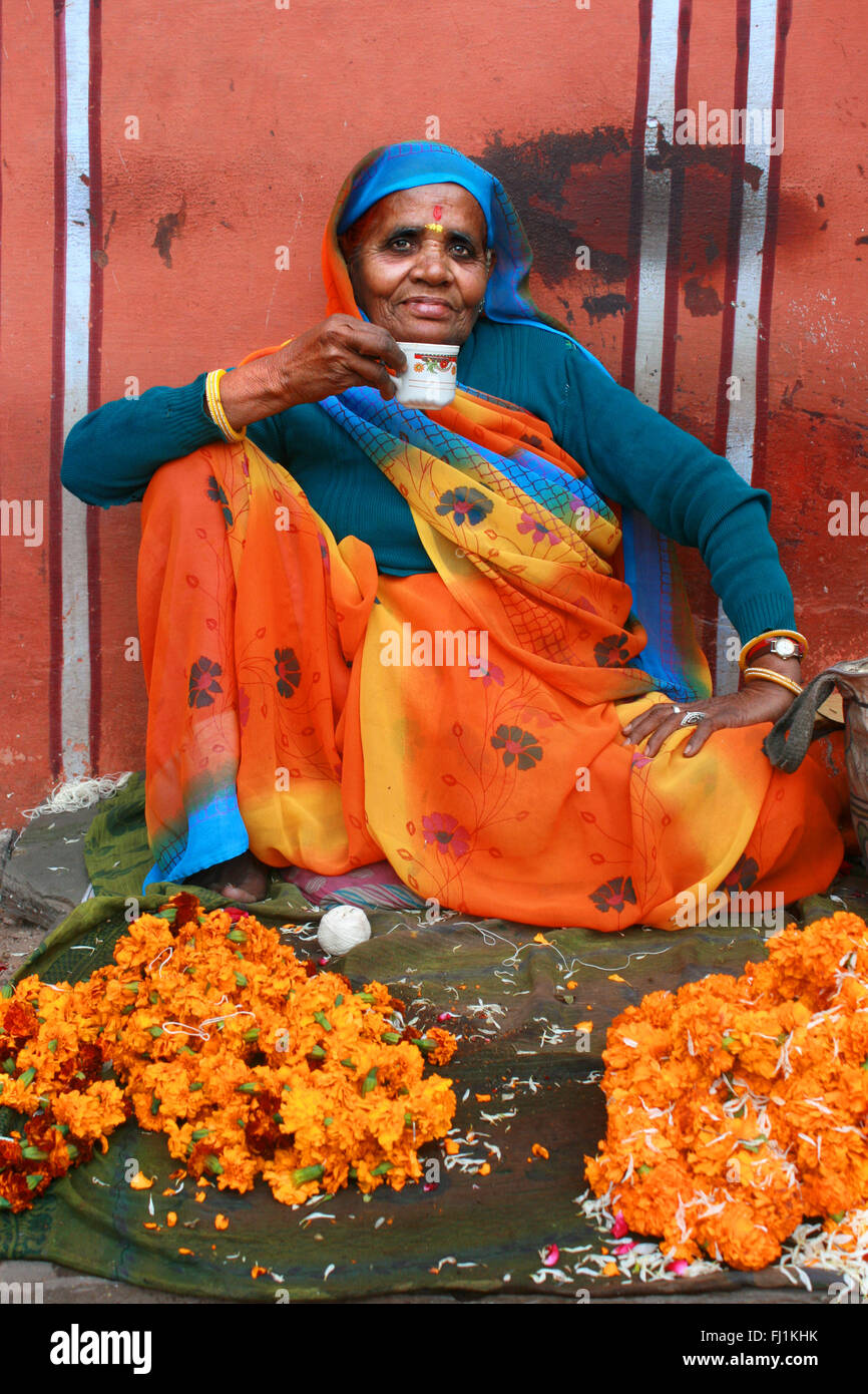 Woman selling flowers and drinking tea in Jaipur, India Stock Photo