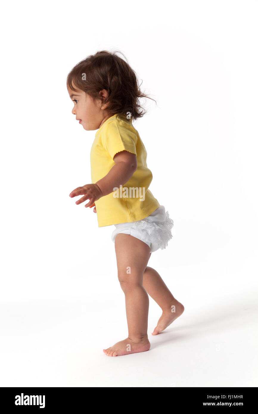 Baby girl walking for the first time on white background Stock Photo
