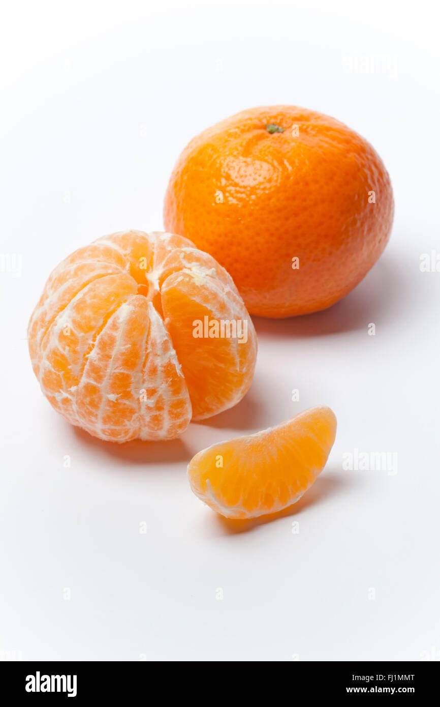 Fresh Tangerine, peeled and with a cut on white background Stock Photo