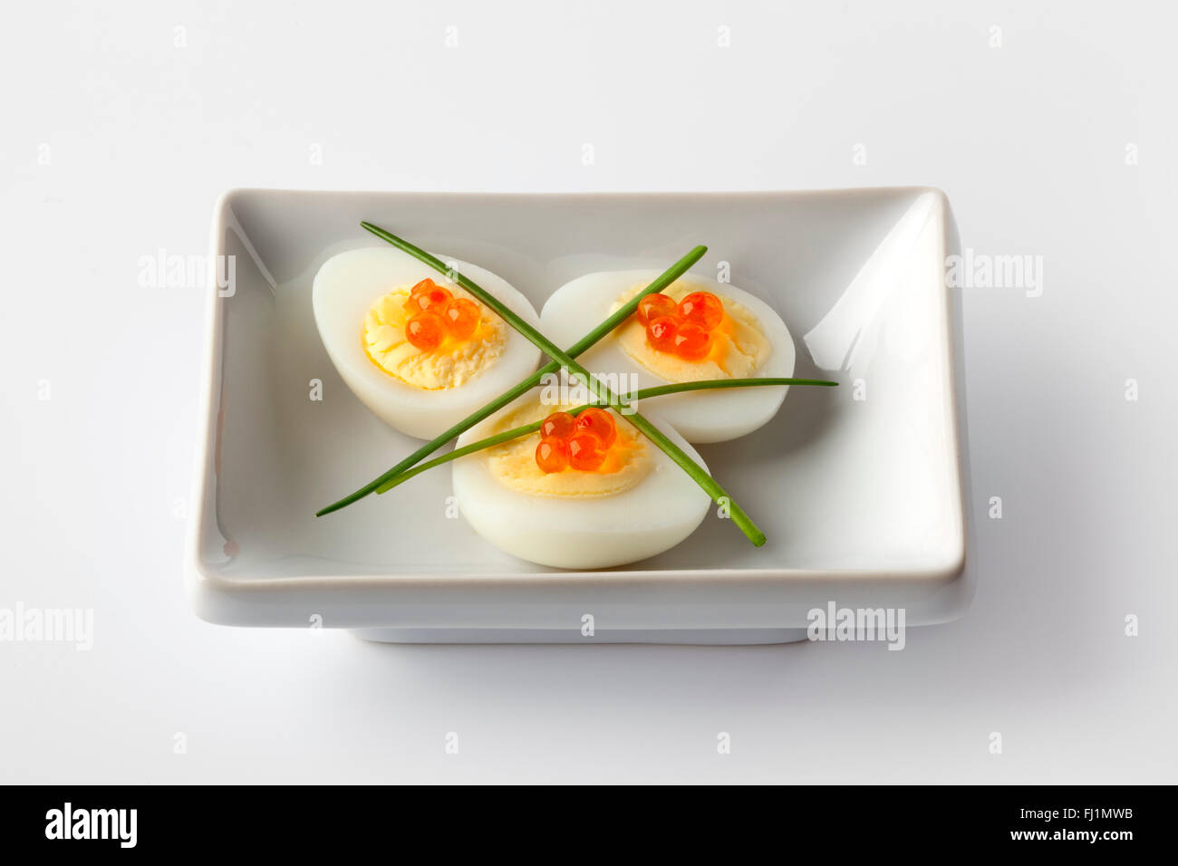 Boiled quail eggs with trout eggs and chive Stock Photo