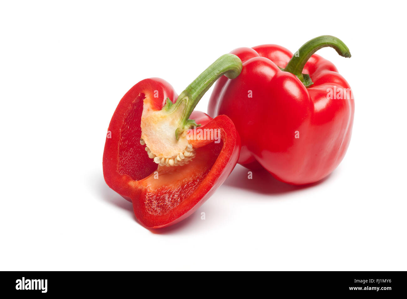 One and a half fresh red bell pepper on white background Stock Photo