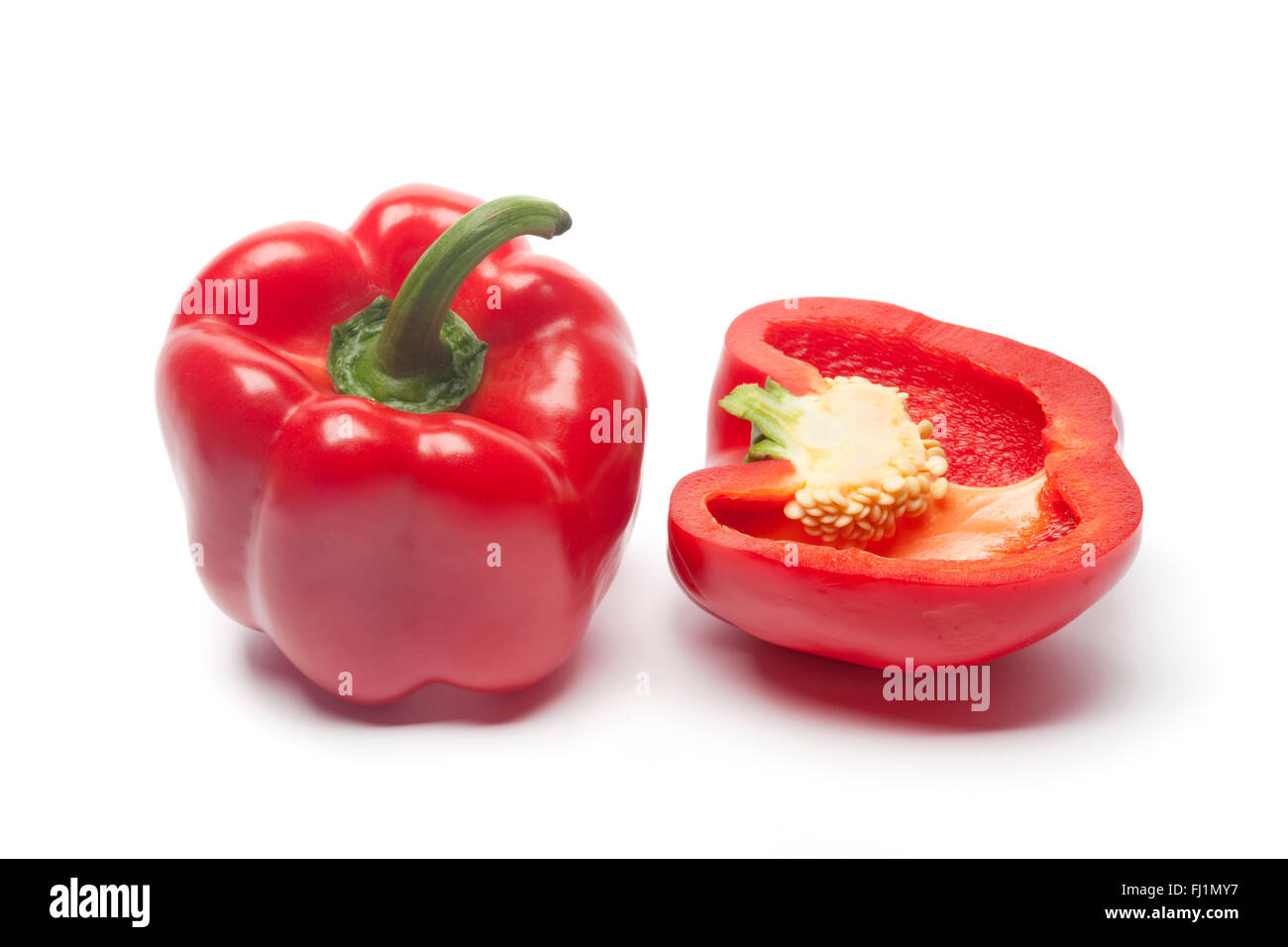 One and a half fresh red bell pepper on white background Stock Photo