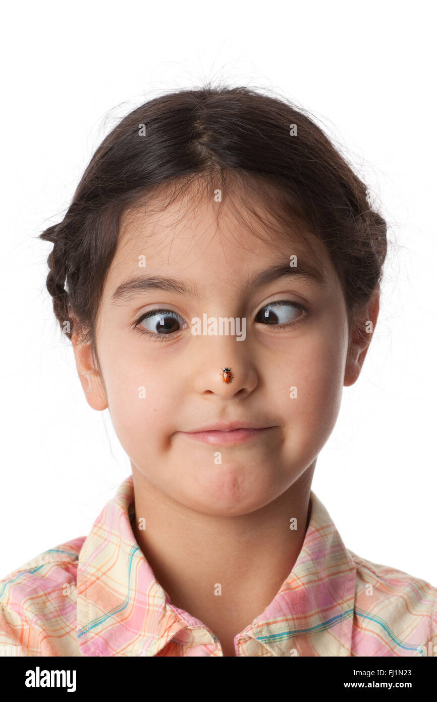 Springtime, little girl with a ladybird on her nose on white background Stock Photo