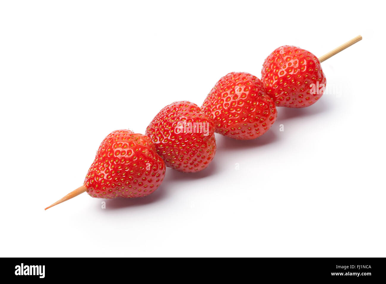 Fresh strawberries on a wooden stick on white background Stock Photo