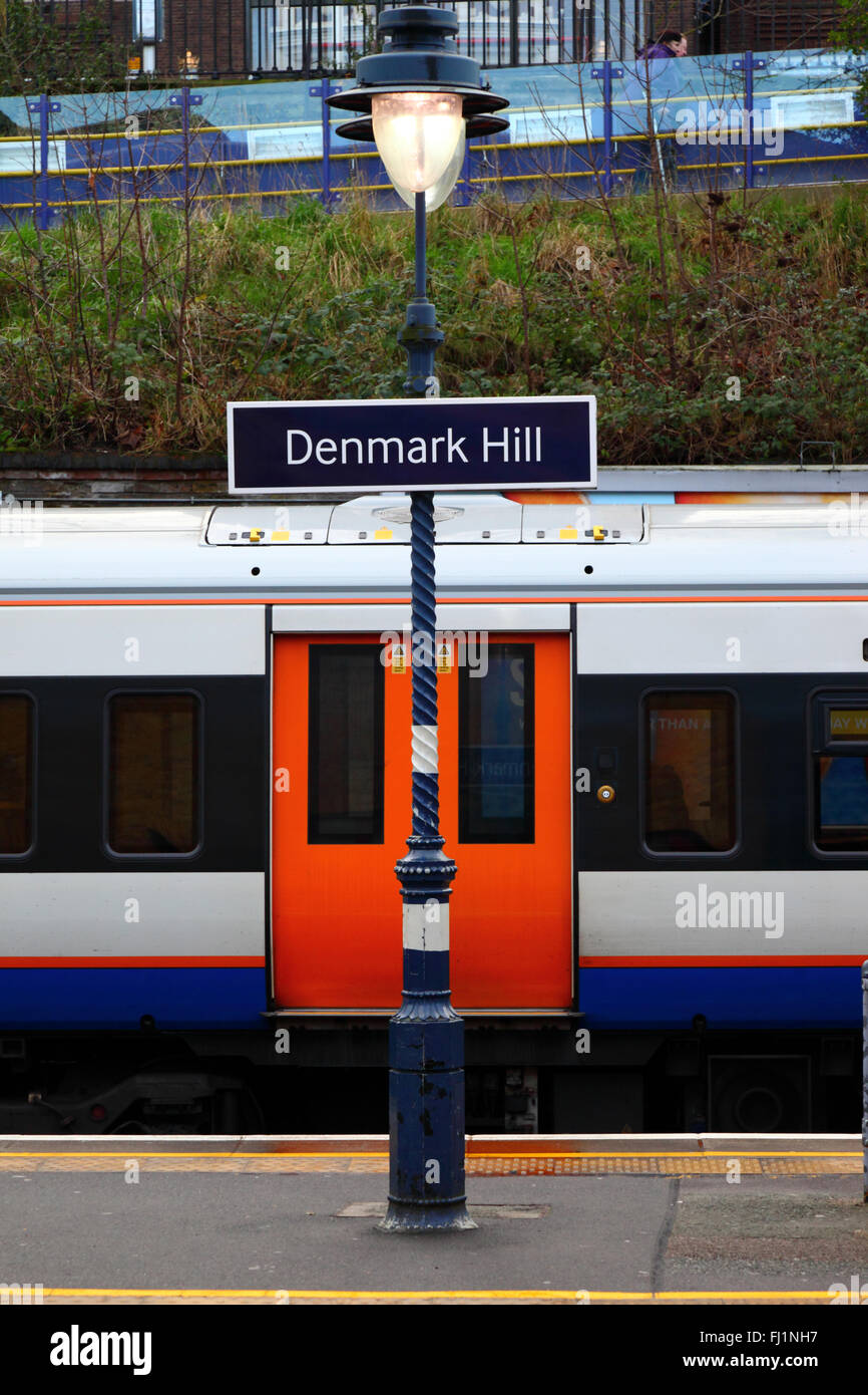 London Overground train with orange doors and Denmark Hill railway station sign, Camberwell, London, England Stock Photo