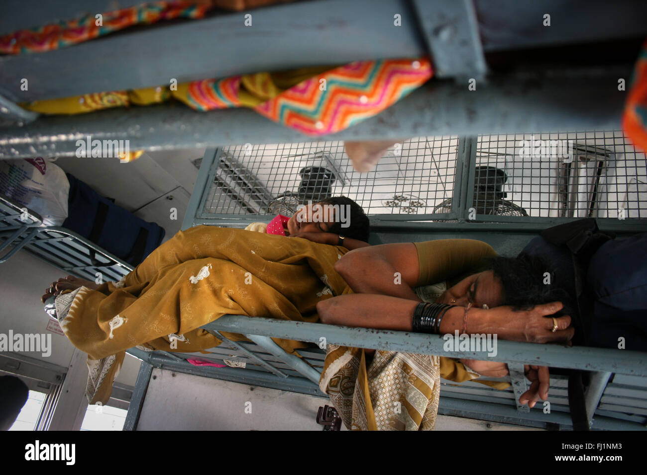 Woman sleeping with her baby in train arriving at Bangalore, India Stock Photo