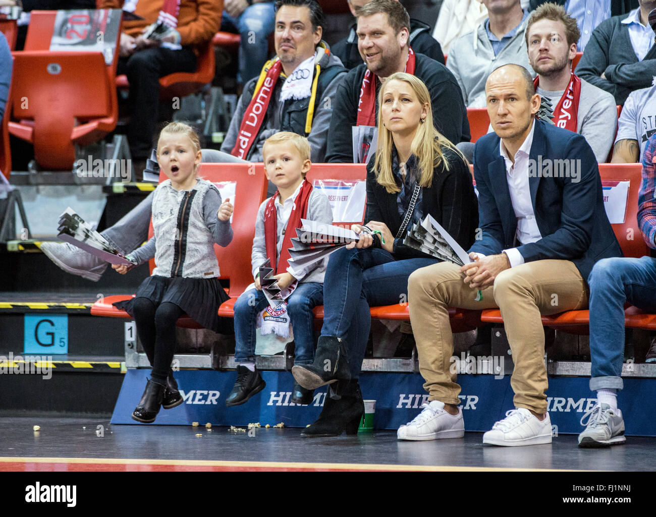 Munich, Germany. 28th Feb, 2016. FC Bayern Munich soccer player Arjen Robben, his wife Bernadien Eillert and two of their children sit in the stands at the German Bundesliga basketball game between Bayern Munich and ALBA Berlin in the Audi Dome in Munich, Germany, 28 February 2016. Photo: MARC MUELLER/dpa/Alamy Live News Stock Photo