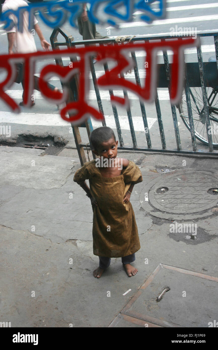 Poor dirty  young child is begging asking for money in the center of Kolkata Stock Photo