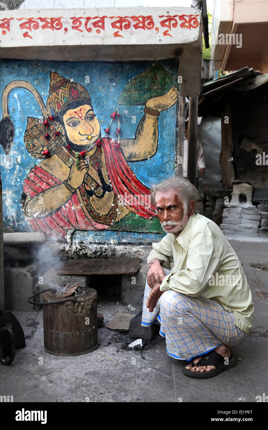 Man with skin disease ' vitiligo ' poses in front of Lord Hanuman painting in the streets of Kolkata , India Stock Photo