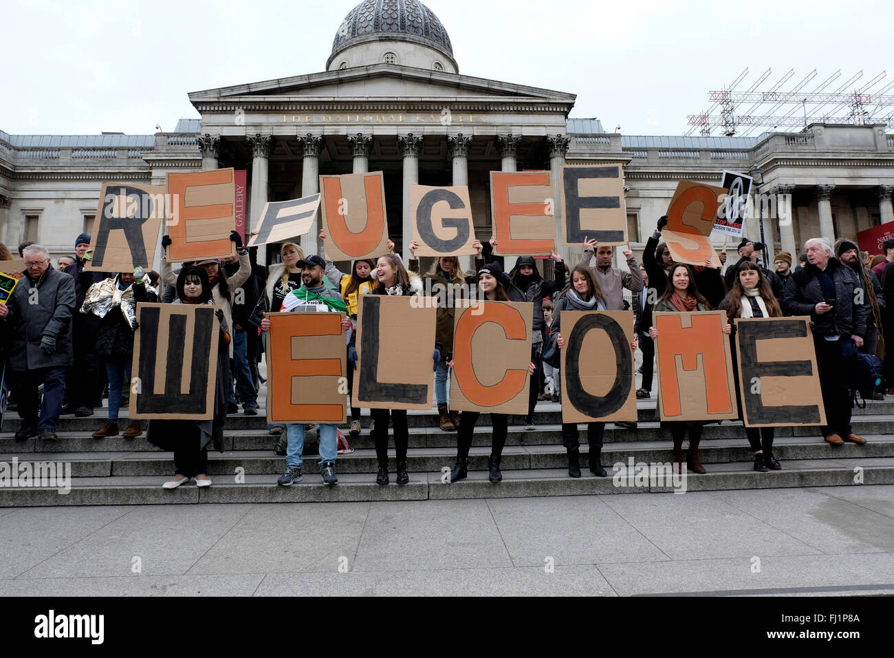 Protesters holding placard reading 'Refugees welcome' Stock Photo