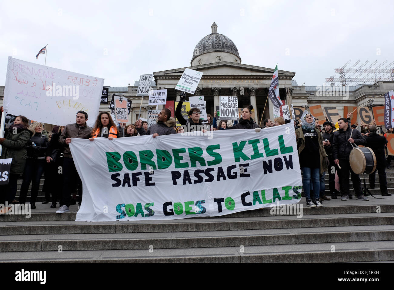 Protesters hold a banner reading "Borders kill, safe passage now" Stock Photo