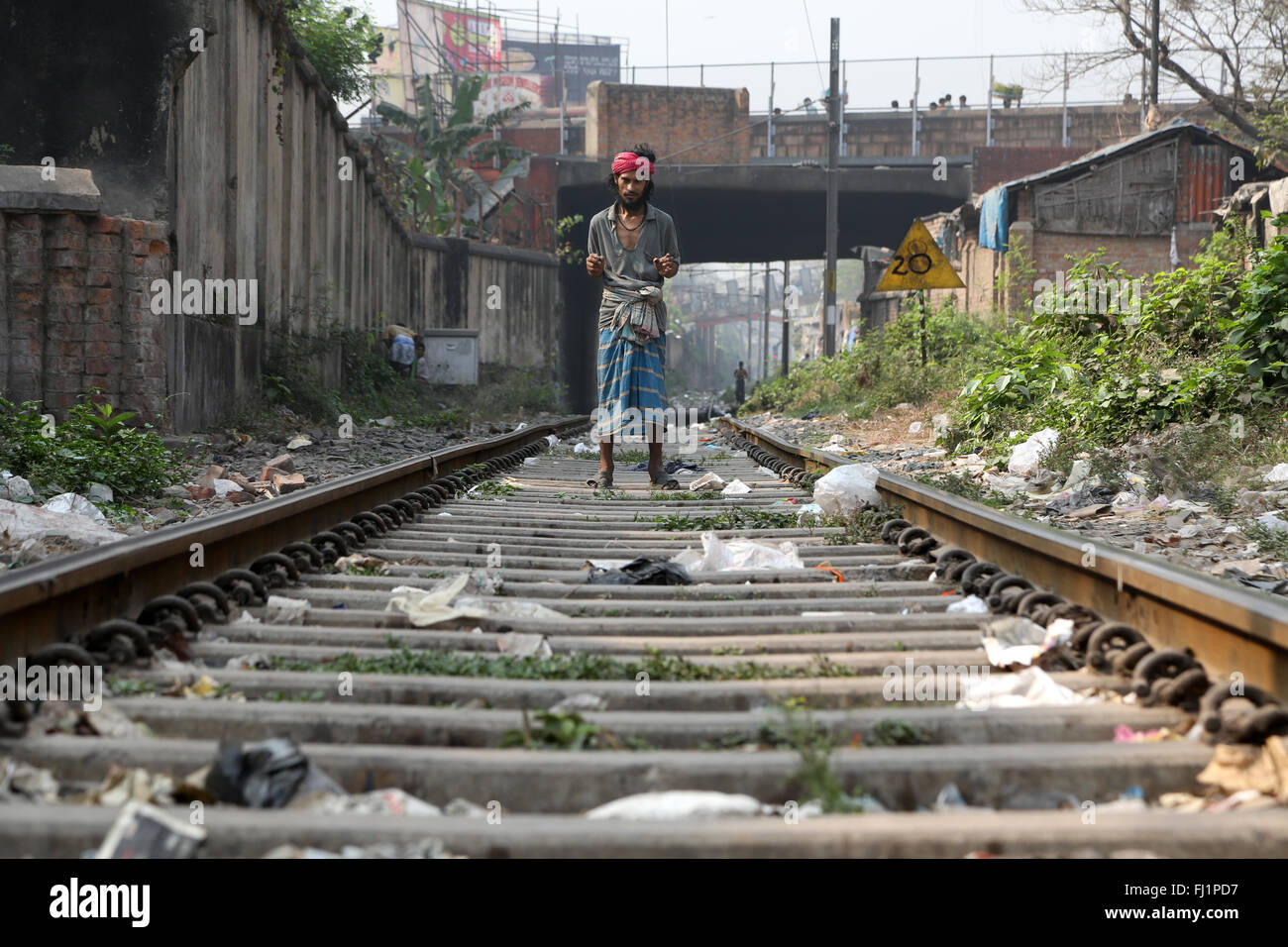 Man stands alone on train rails in Howrah , Kolkata, India Stock Photo