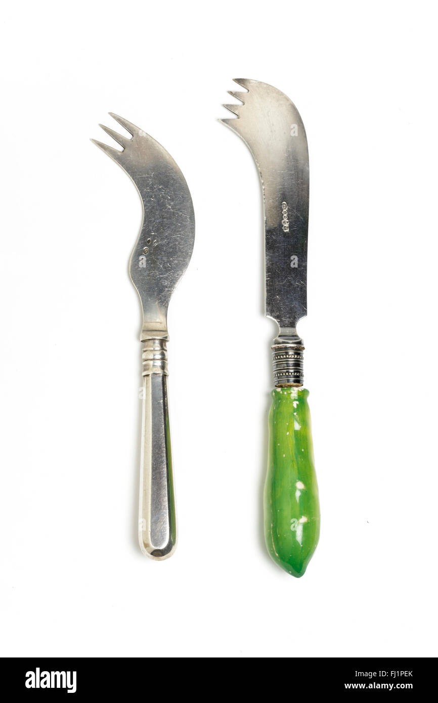 One-handed or amputeee cutlery, combining a knife and fork in one utensil.  Left: French, silver; right: English electro-plated Stock Photo